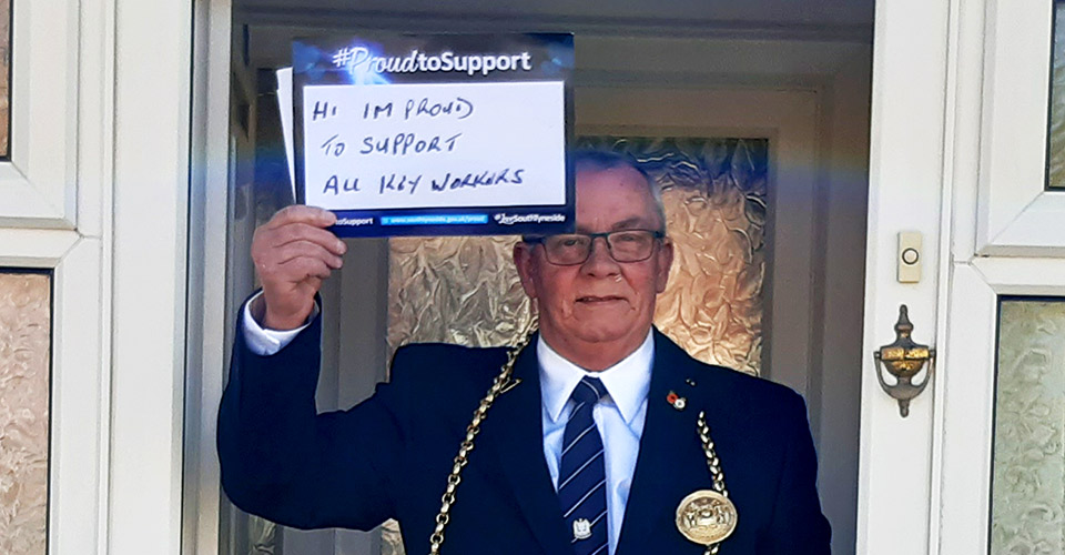 Image of the Mayor of South Tyneside, Councillor Norman Dick holding up a 'Proud To Support' sign